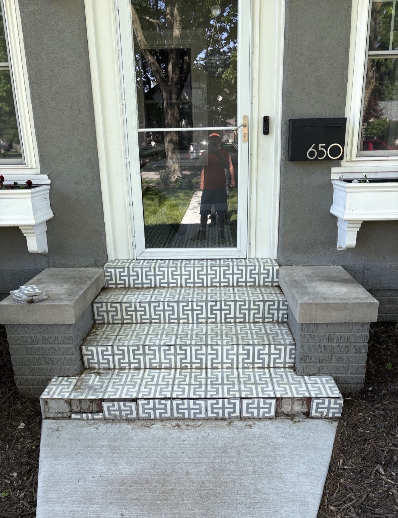 Front porch with old tile and worn steps before restoration in Des Moines, IA